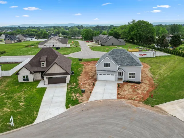an aerial view of a house with green yard and outdoor seating