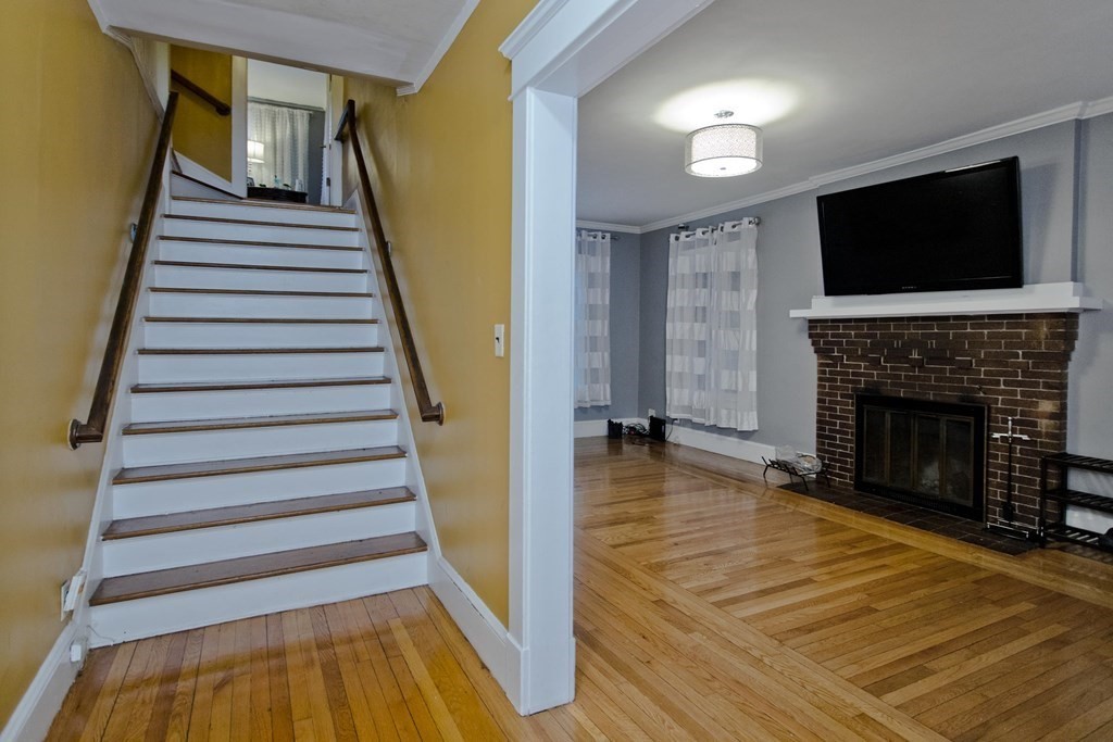 177 Belvidere Street Springfield, MA 01108 - Photo 4 of 24 a view of a livingroom with wooden floor and a fireplace