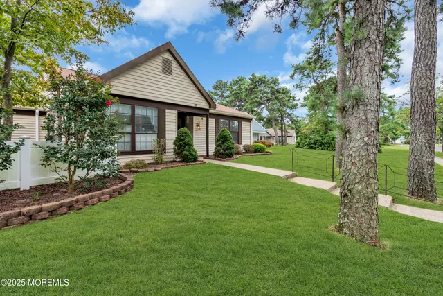 a front view of a house with a yard and trees