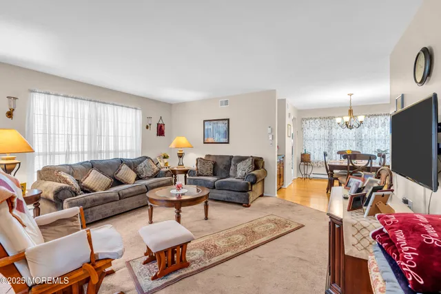 a living room with furniture a flat screen tv and a window