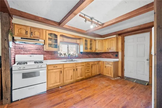 a large kitchen with stainless steel appliances granite countertop a stove and a refrigerator
