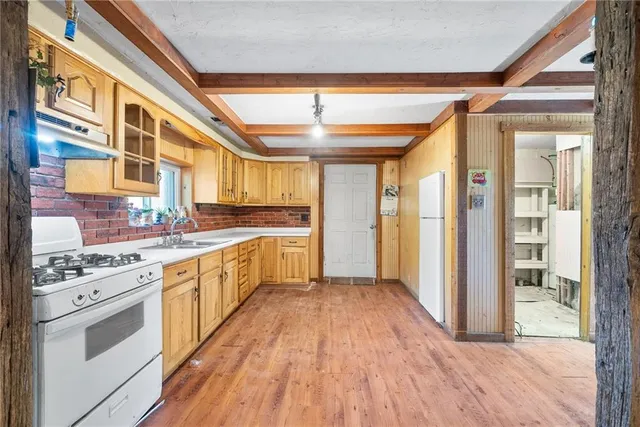 a large white kitchen with stainless steel appliances granite countertop a stove and cabinets
