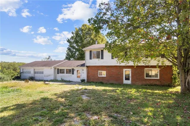 a view of a house with a big yard and a large tree