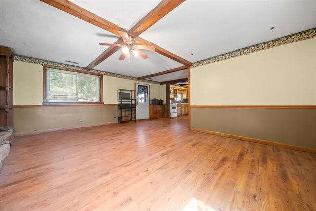 a view of an empty room with window and fireplace