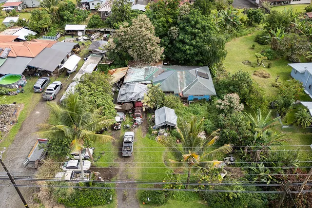 an aerial view of residential house with outdoor space and trees all around