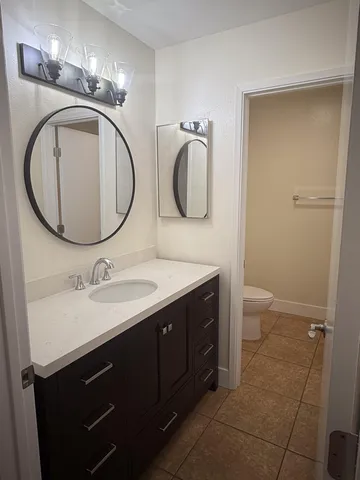 a bathroom with a toilet sink and mirror