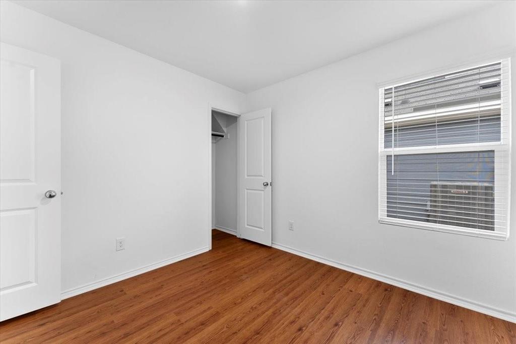 211 Herman Lane Princeton, TX 75407 - Photo 16 of 40 a view of an empty room with wooden floor and a window