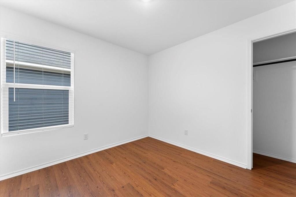 211 Herman Lane Princeton, TX 75407 - Photo 20 of 40 a view of an empty room with wooden floor and a window