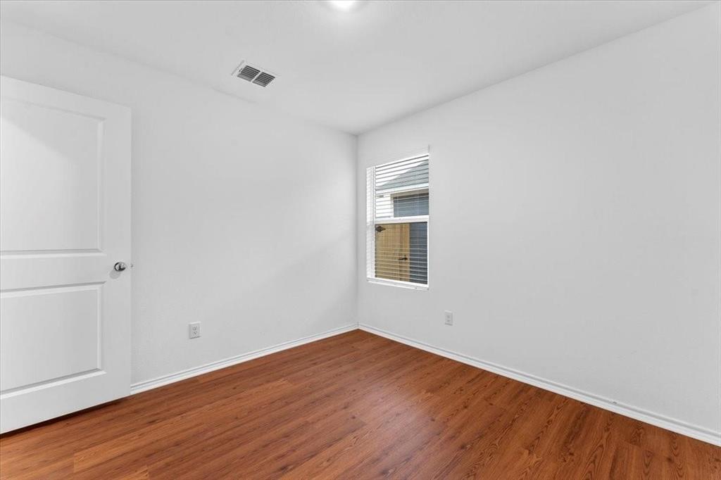 211 Herman Lane Princeton, TX 75407 - Photo 23 of 40 a view of an empty room with wooden floor and a window