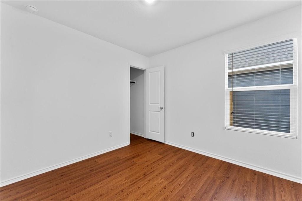 211 Herman Lane Princeton, TX 75407 - Photo 24 of 40 a view of an empty room with wooden floor and a window