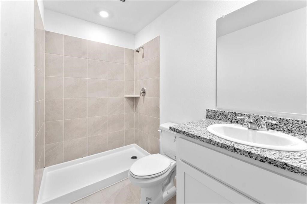 211 Herman Lane Princeton, TX 75407 - Photo 30 of 40 a bathroom with a granite countertop sink a toilet and shower