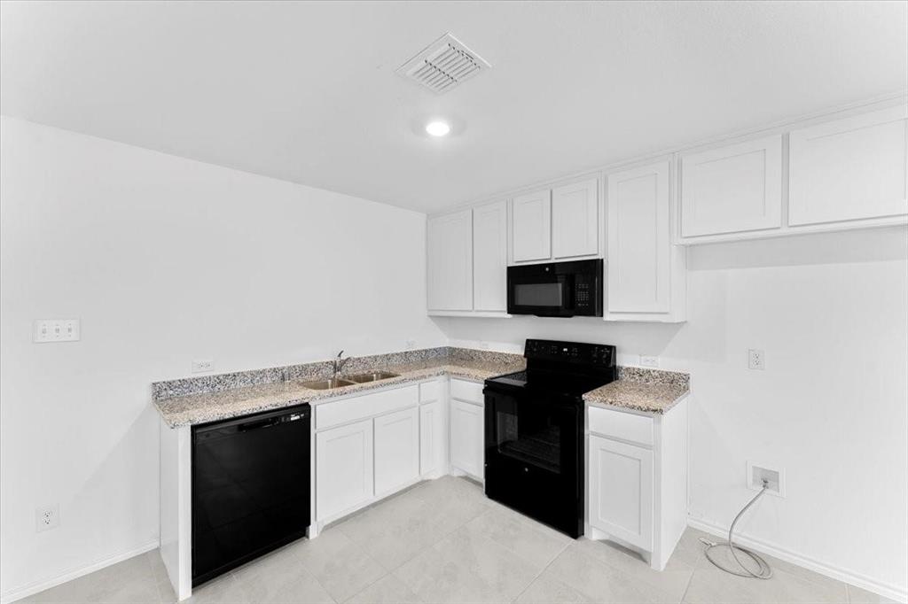 211 Herman Lane Princeton, TX 75407 - Photo 9 of 40 a kitchen with a sink and a stove top oven with wooden floor
