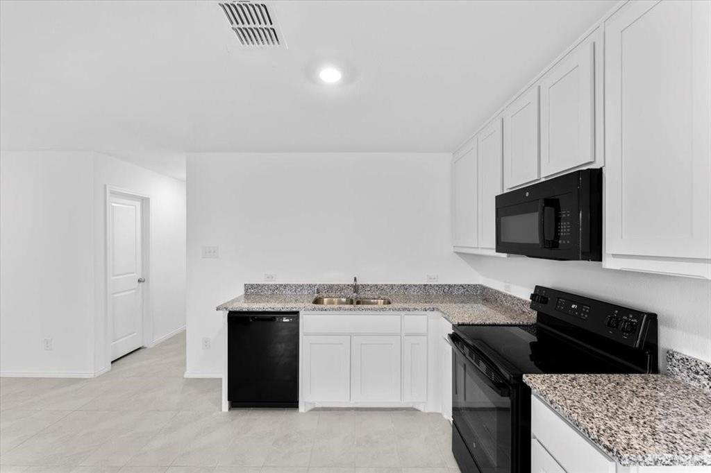 211 Herman Lane Princeton, TX 75407 - Photo 10 of 40 a kitchen with a stove and a microwave
