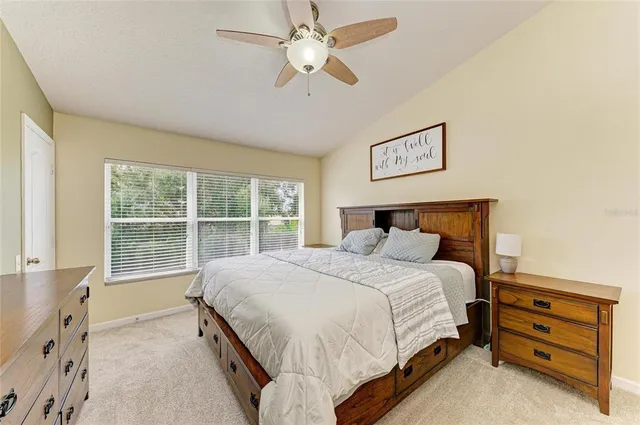 a bedroom with a large bed and a chandelier fan