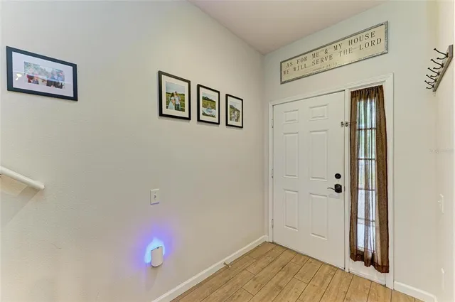 a view of a hallway with wooden floor and stairs