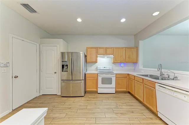 a large kitchen with a lot of counter space and wooden floor