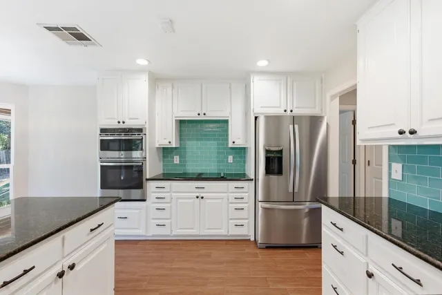 a kitchen with stainless steel appliances a refrigerator sink and microwave