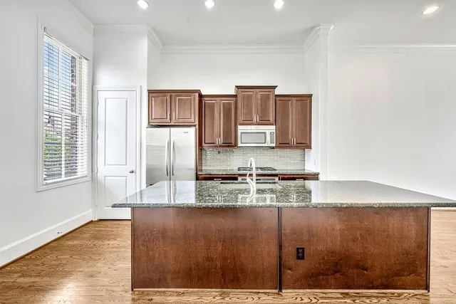 a kitchen with kitchen island a counter top space cabinets and stainless steel appliances