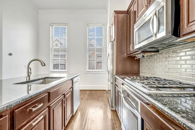 a kitchen with stainless steel appliances granite countertop a sink stove and cabinets