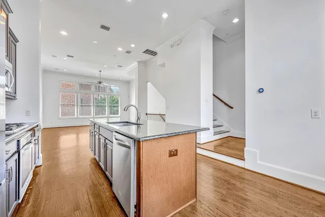 an open kitchen with a sink and wooden floor