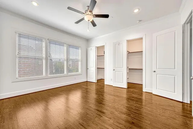 a view of an empty room with a window and wooden floor