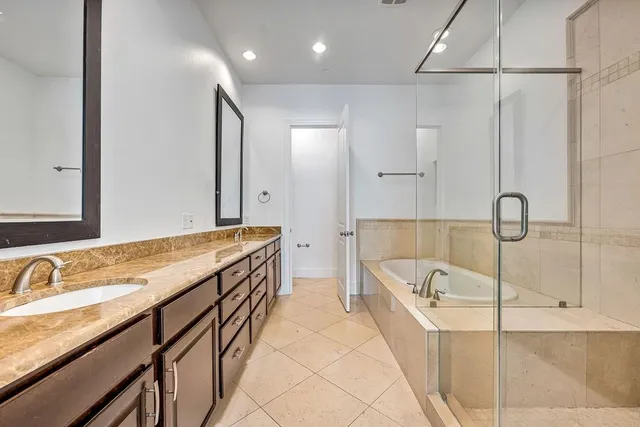 a spacious bathroom with a tub sink and mirror
