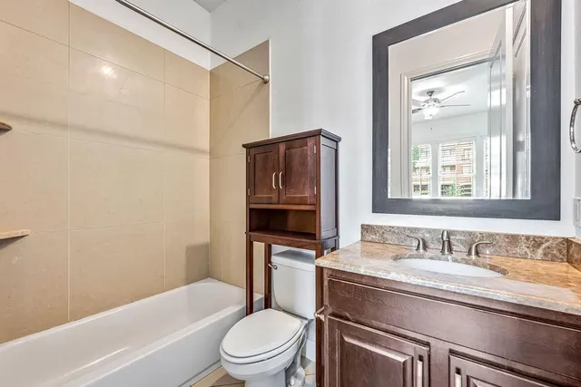a bathroom with a granite countertop toilet sink and mirror