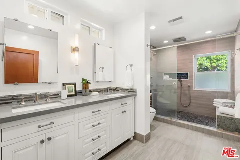 a large bathroom with a granite countertop sink mirror and shower