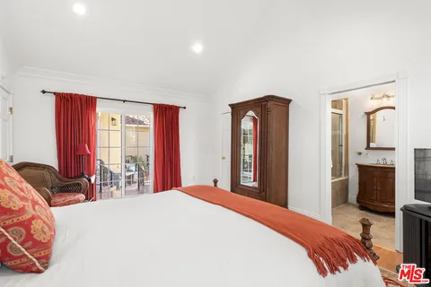 a bedroom with a large bed and flat tv screen