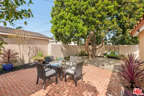 a view of a patio with a table and chairs under an umbrella