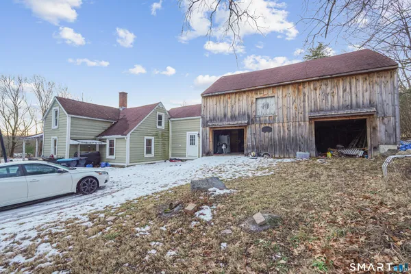 a view of a house with a yard and fire pit