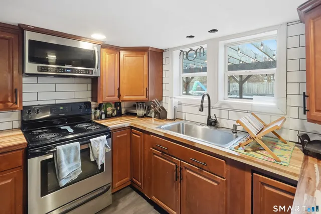 a kitchen with a sink stove top oven and cabinets