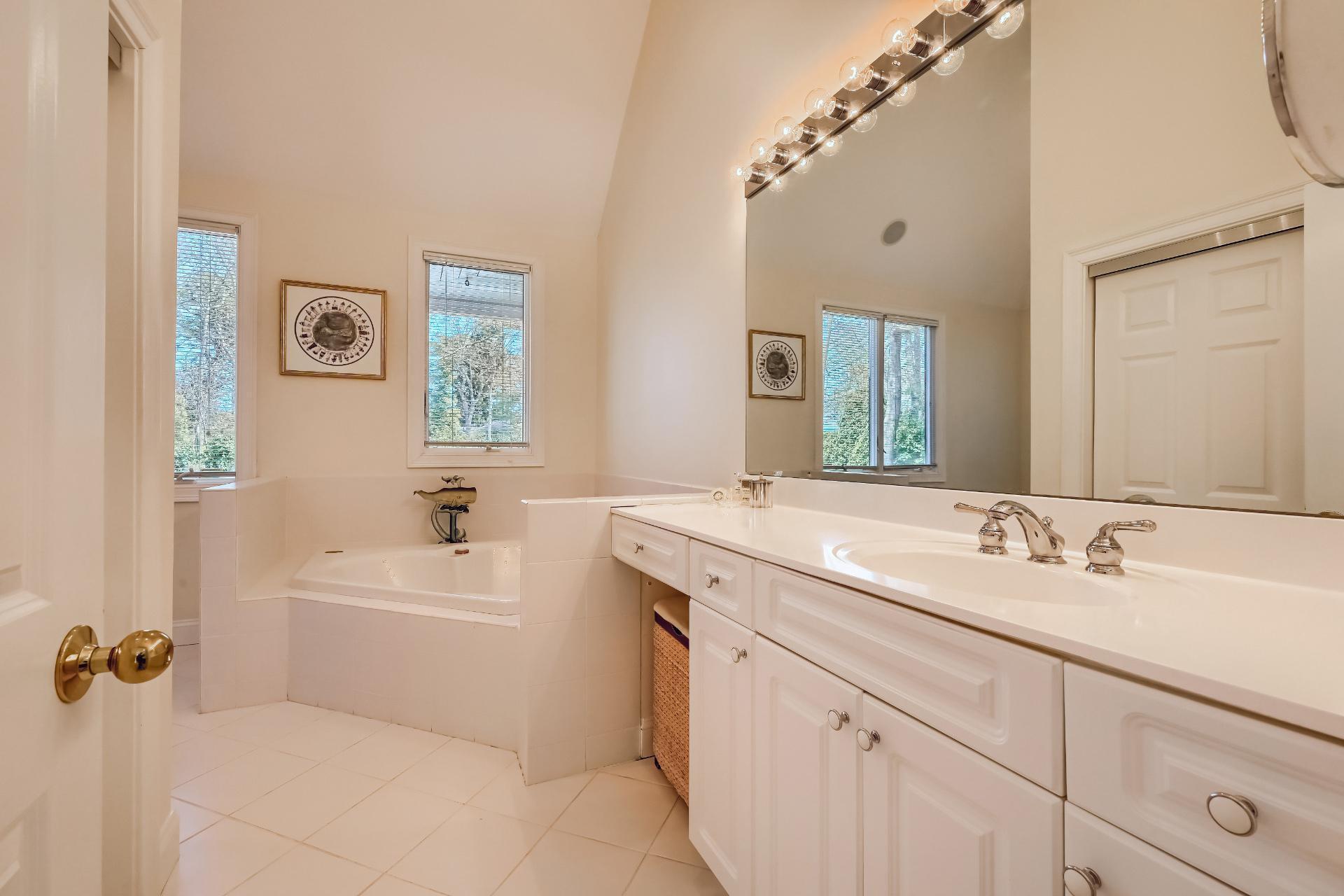 4 Tide Run Mashpee, MA 02649 - Photo 16 of 46 a bathroom with a double vanity sink a mirror and a bathtub