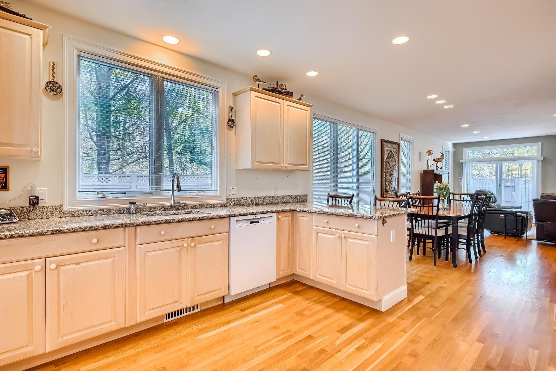 4 Tide Run Mashpee, MA 02649 - Photo 7 of 46 a open kitchen with granite countertop a stove a sink a dining table and chairs with wooden floor
