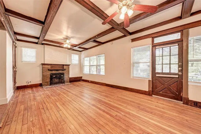 a view of empty room with wooden floor and fireplace
