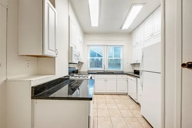a kitchen with a sink a stove and a refrigerator
