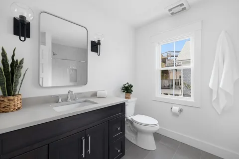 a bathroom with a toilet a sink and mirror