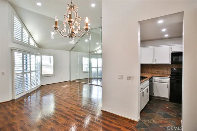 a view of a kitchen with a sink and dishwasher with wooden floor