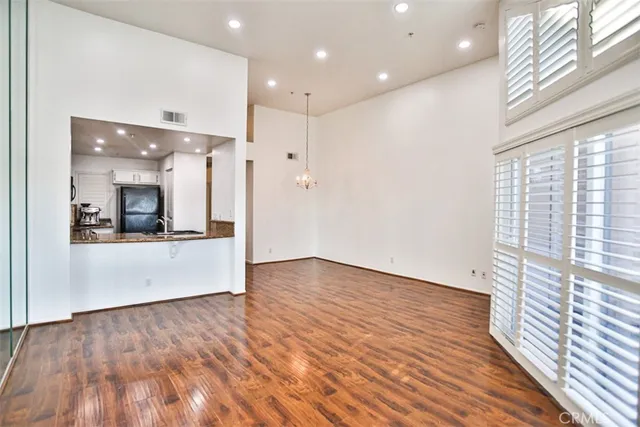 a view of a hallway with wooden floor and a bathroom