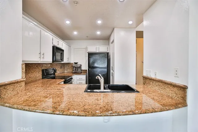 a kitchen with sink a refrigerator and microwave