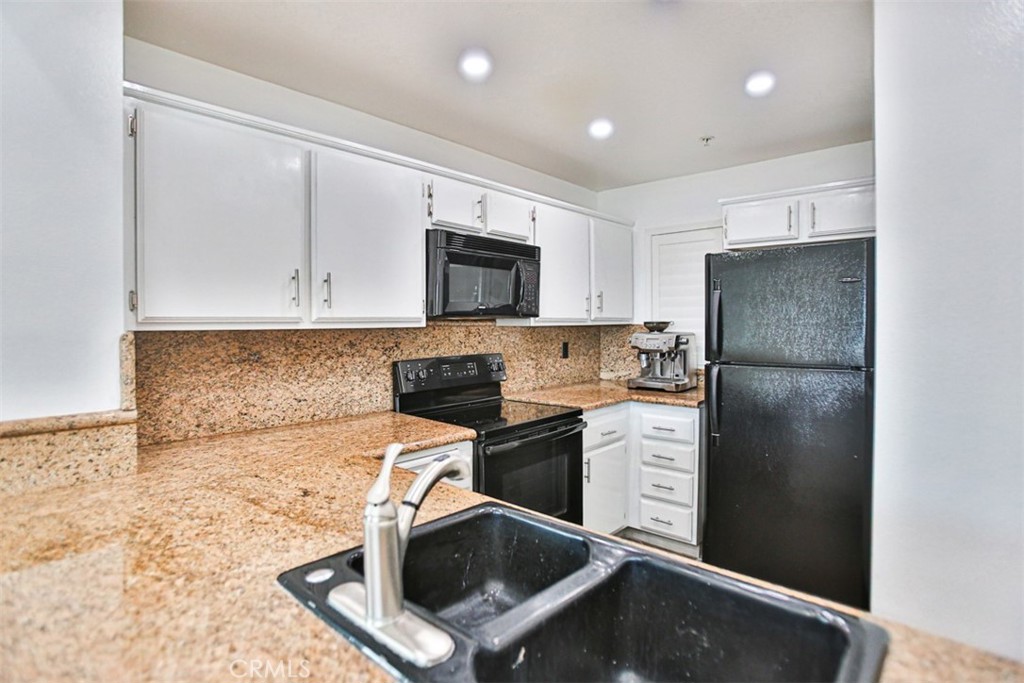 1200 Pacific Coast Highway, Unit 423 Huntington Beach, CA 92648 - Photo 34 of 40 a kitchen with a refrigerator sink and microwave