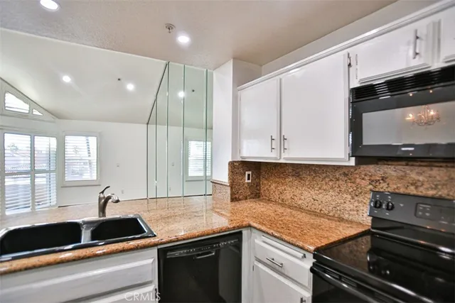 a kitchen with granite countertop a sink and a stove