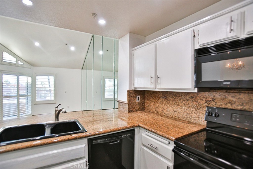 1200 Pacific Coast Highway, Unit 423 Huntington Beach, CA 92648 - Photo 36 of 40 a kitchen with granite countertop a sink and a stove
