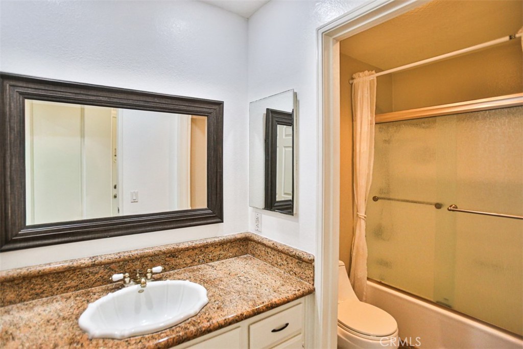 1200 Pacific Coast Highway, Unit 423 Huntington Beach, CA 92648 - Photo 39 of 40 a bathroom with a granite countertop sink toilet and shower