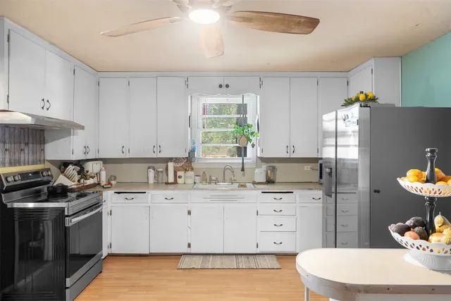 a kitchen with a sink a stove a refrigerator and cabinets