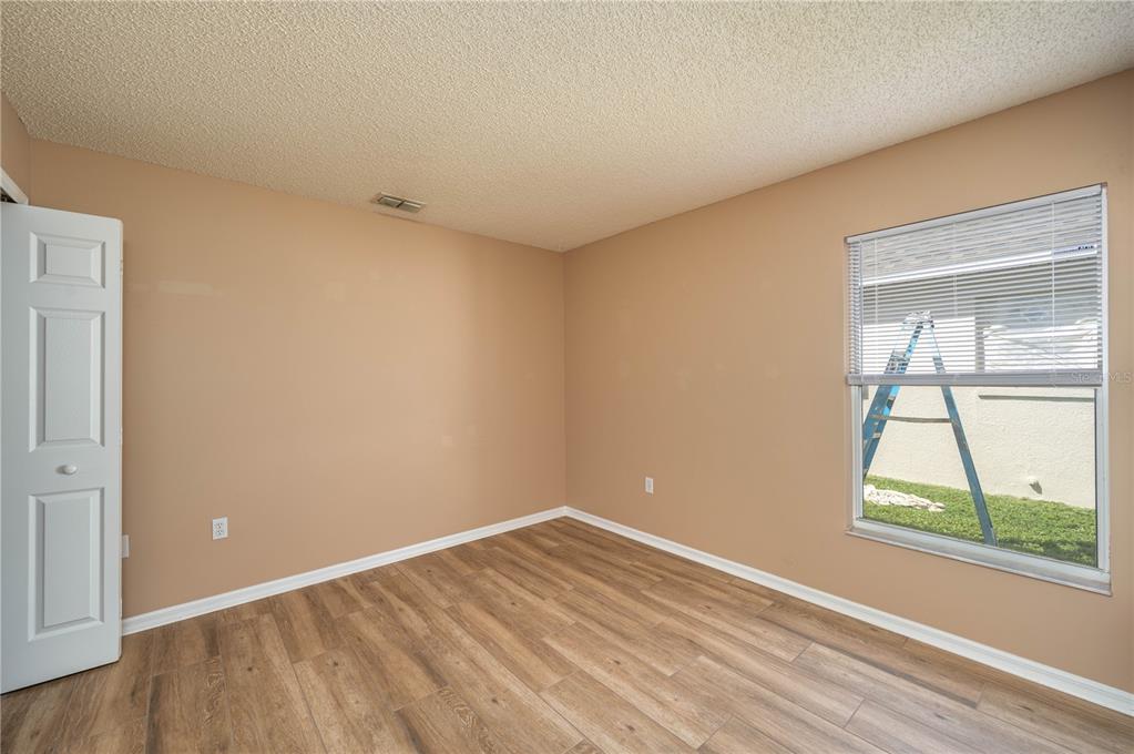 126 Piano Lane Davenport, FL 33896 - Photo 14 of 24 wooden floor in an empty room with a window