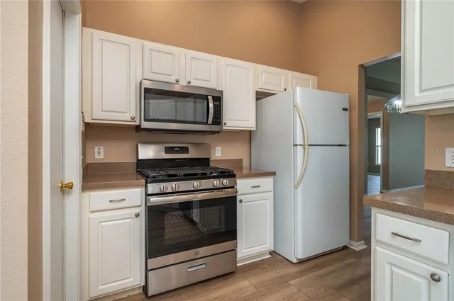 a kitchen with white cabinets and stainless steel appliances