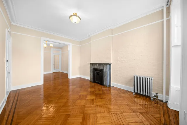 a view of empty room with wooden floor and fireplace