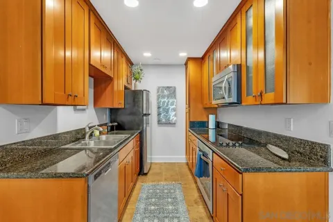 a kitchen with stainless steel appliances granite countertop a stove a sink and a refrigerator