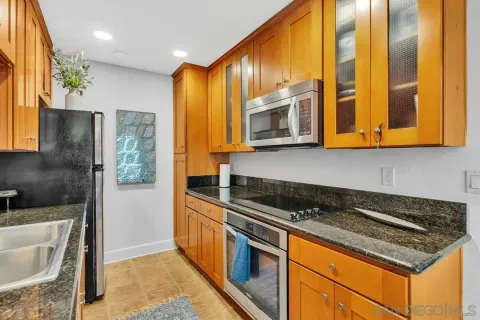 a kitchen with stainless steel appliances granite countertop a stove a sink and a microwave